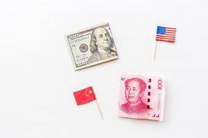 Trade war between China and America. Cash money one hundred dollars and yuan bills on white