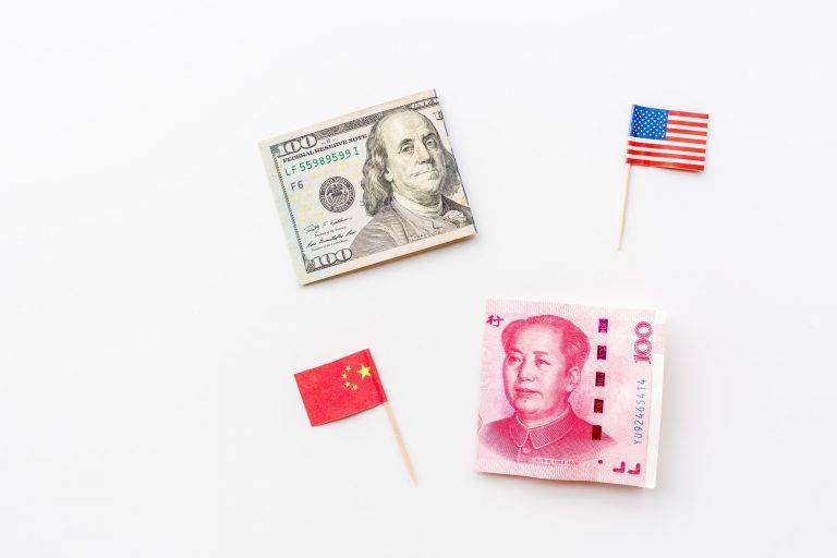 Trade war between China and America. Cash money one hundred dollars and yuan bills on white