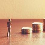 Miniature people looking future with stack coin about financial and money savings concept.